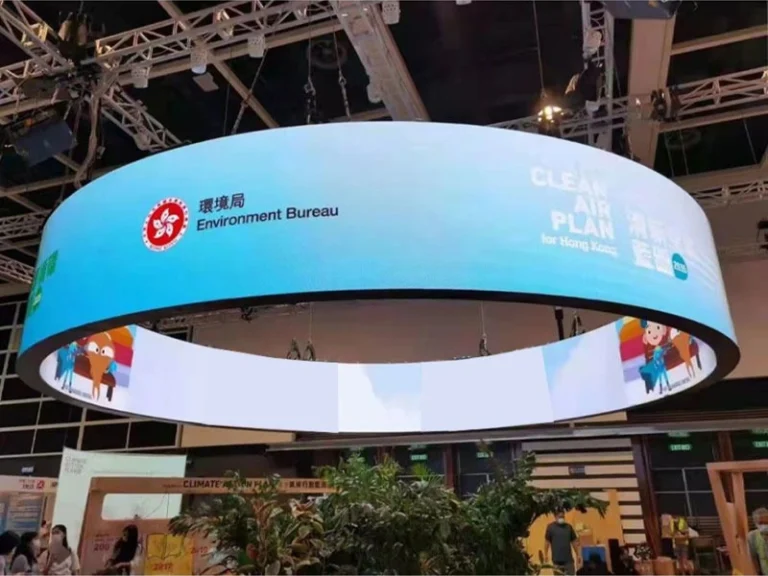 A circular, double-sided LED display suspended within the exhibition hall